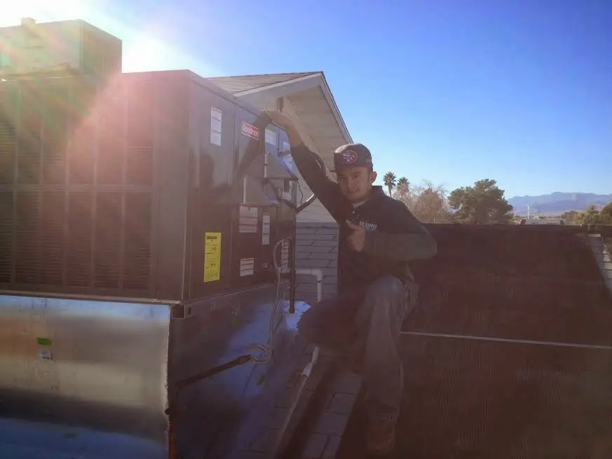 HVAC technician performing Heat Pump Repair on a rooftop unit in Ulster
